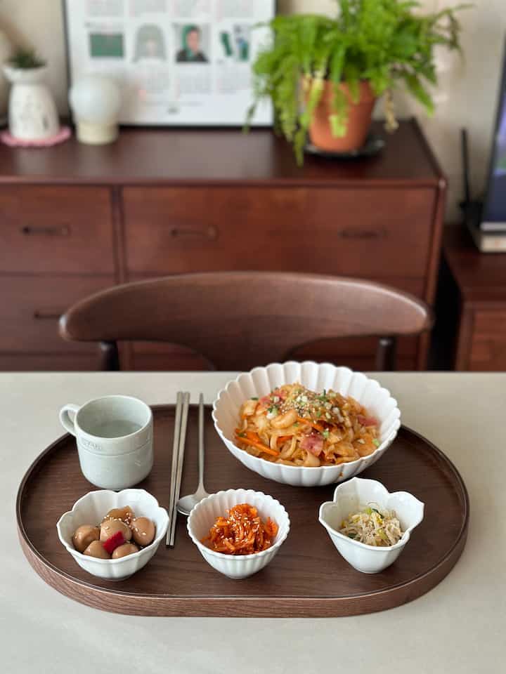 ナチュラルな木目調のテーブルに無地白磁と手作り料理が配置された雰囲気のあるインテリア