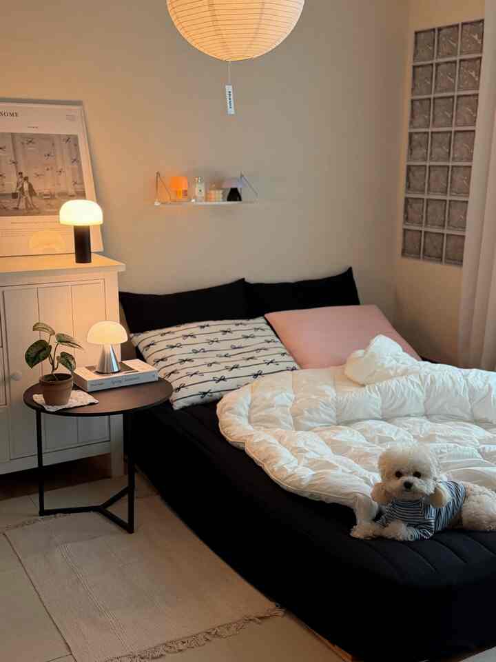 白と黒のトーンの寝室、ムードランプとミニマルな家具が配置された雰囲気のあるインテリア