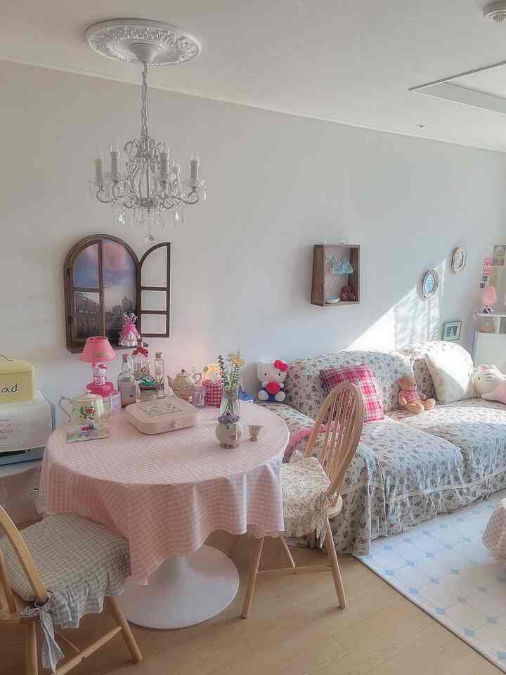 パステルピンクと花柄が調和したリビング、丸いダイニングテーブルとシャンデリアが雰囲気のある空間を演出