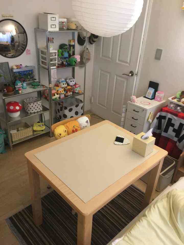 ナチュラルカラーのダイニングルーム、木製のダイニングテーブルと金属製の棚に並んだ様々なぬいぐるみが配置された雰囲気のあるインテリア