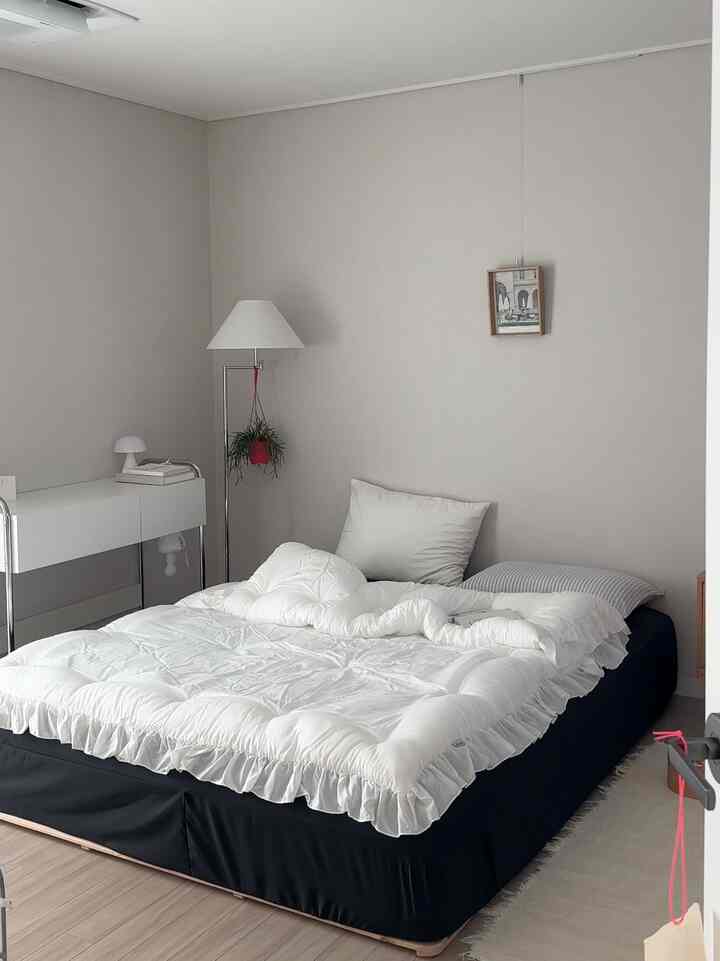 Neutral-toned bedroom with white bedding in mid-century modern style, clean and calm atmosphere