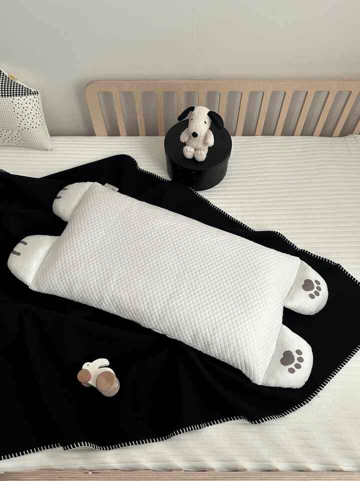 白と黒のトーンの寝室、木製ベッドフレームと枕、スロー、赤ちゃん用おもちゃが配置された雰囲気のあるインテリア