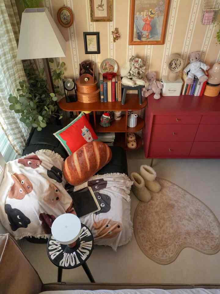 アイボリーとレッドのトーンが調和したヴィンテージ寝室空間、ハート型ラグとソファのクッションとスローがアクセントの雰囲気あるインテリア