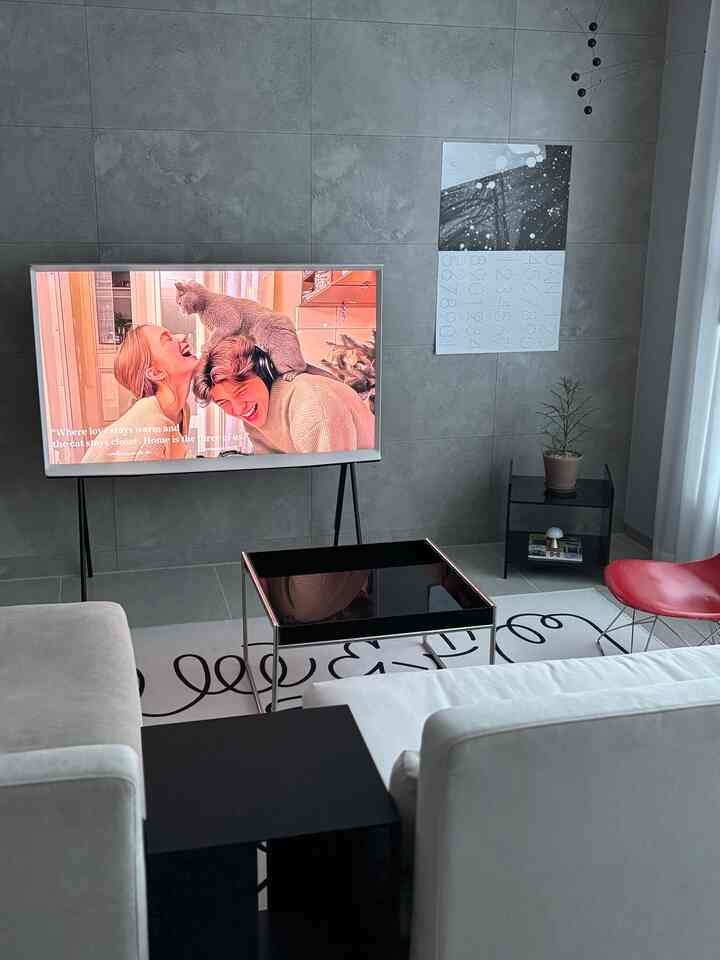 グレーのタイル壁と白いソファ、黒いテーブルが調和したモダンなリビング