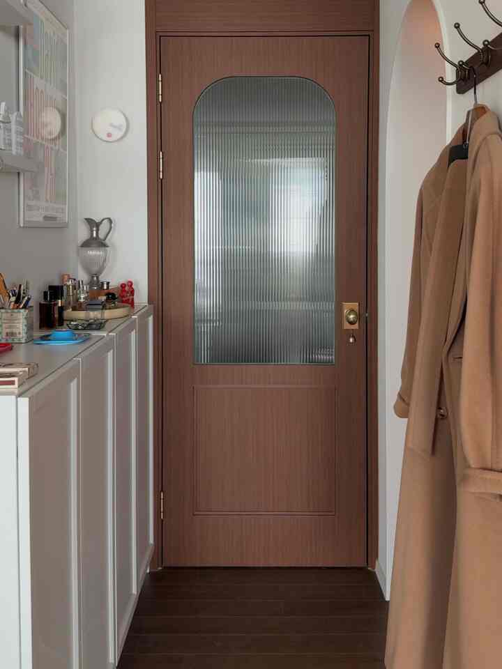 ブラウンの木目調の中扉とホワイトの収納棚が配置された清潔感のある玄関スペース