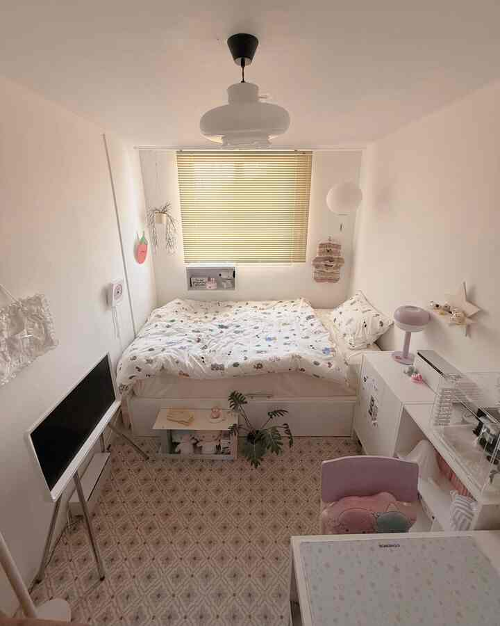 白と黄色のトーンが調和した子供部屋のワンルーム寝室、大きなベッドとキャラクター柄の寝具、効率的な収納スペースが配置された印象的な空間