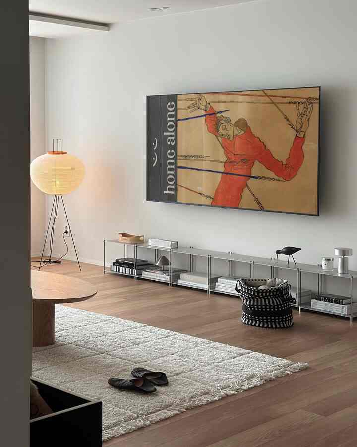 白い壁と木目調フローリングのモダンなリビングルーム、モジュール棚とアカリフロアランプが配置されたシンプルで雰囲気のあるインテリア