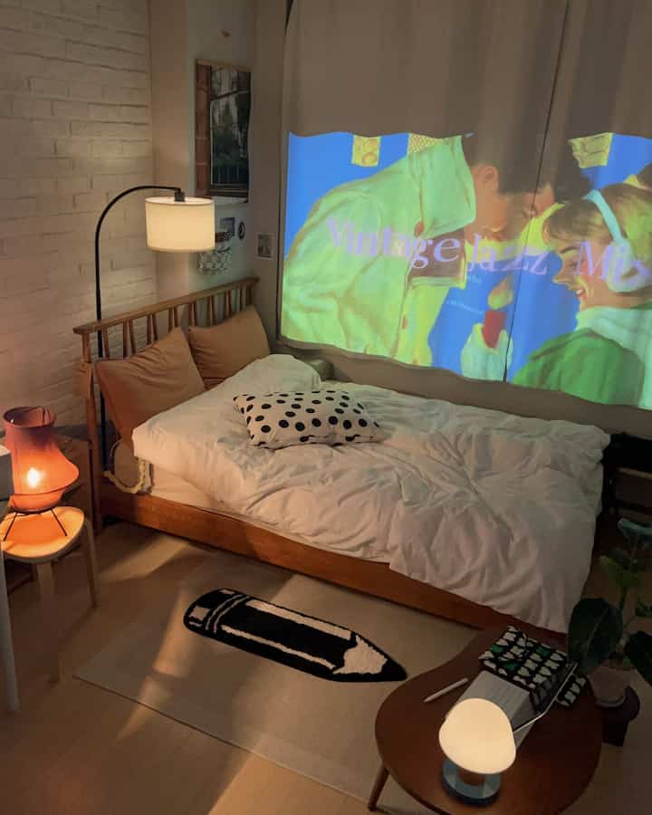 白と茶色のトーンの寝室、木製ベッドフレームとナイトテーブル、フロアランプが配置された雰囲気のあるインテリア