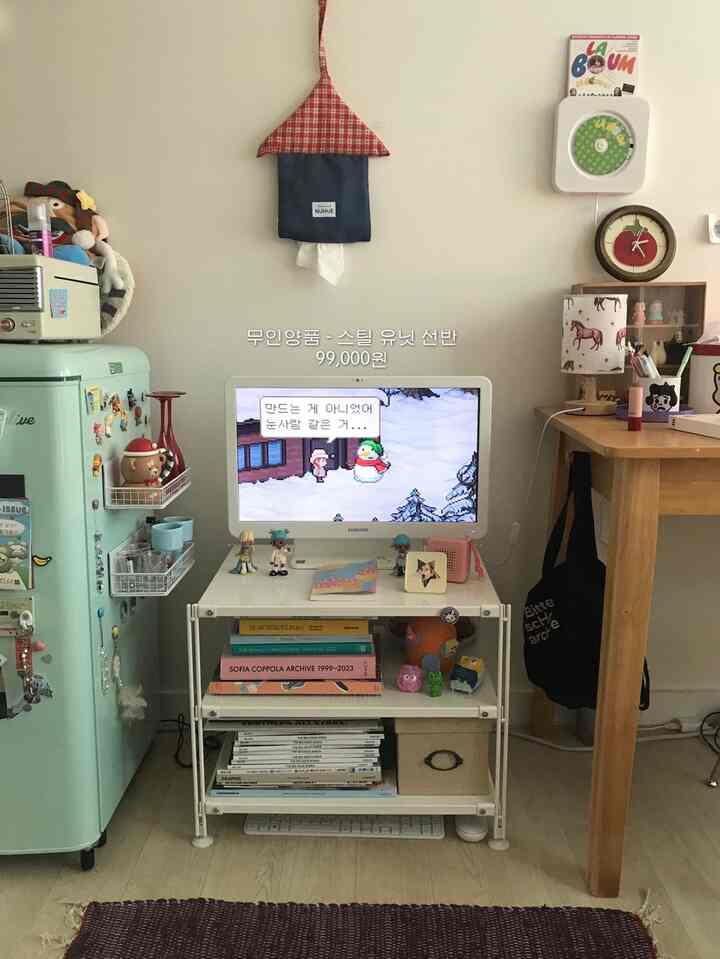 ナチュラルな雰囲気の小さなワンルーム、ヴィンテージ冷蔵庫とデスク、モニタースタンドが配置された居心地の良いホームオフィスのインテリア