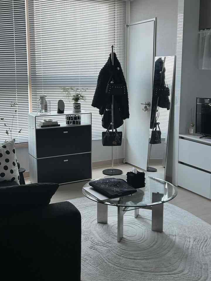 Modern entrance living room with white and black tones, featuring a mid-century full-length mirror and minimalist furniture in a clean layout
