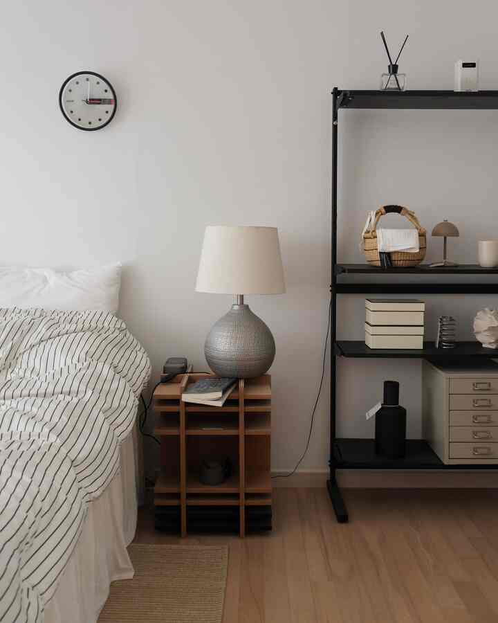 ナチュラルな色調の寝室、ナイトテーブルとテーブルランプが配置されたシンプルでモダンなインテリア