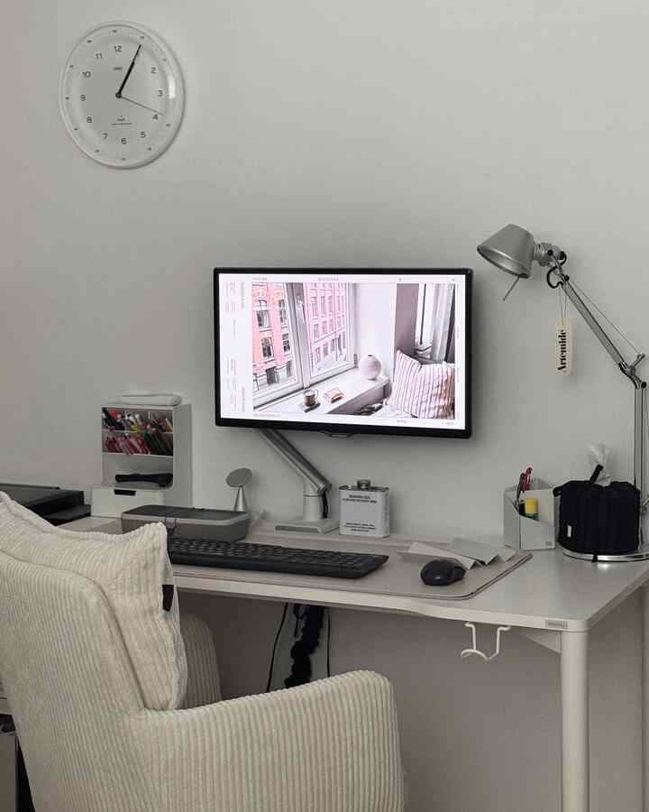 白とグレーのトーンのホームオフィス、整理された机と小物が配置されたシンプルで落ち着いた雰囲気のインテリア