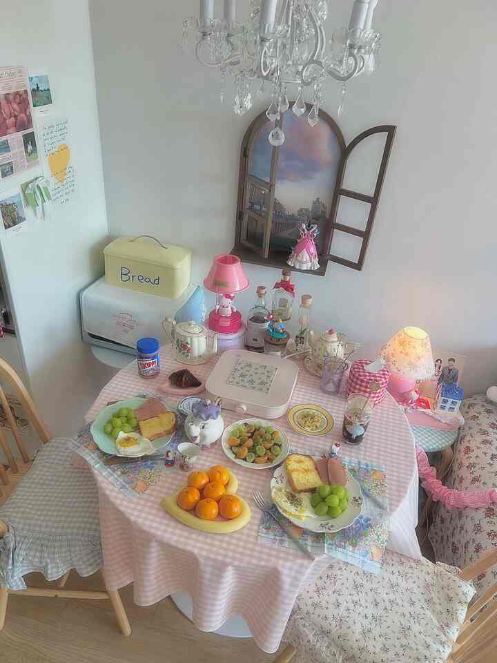 ピンクと白の色調のダイニングルーム、ヴィンテージスタイルのティーカップとテーブルクロスが配置された雰囲気のあるブランチ空間