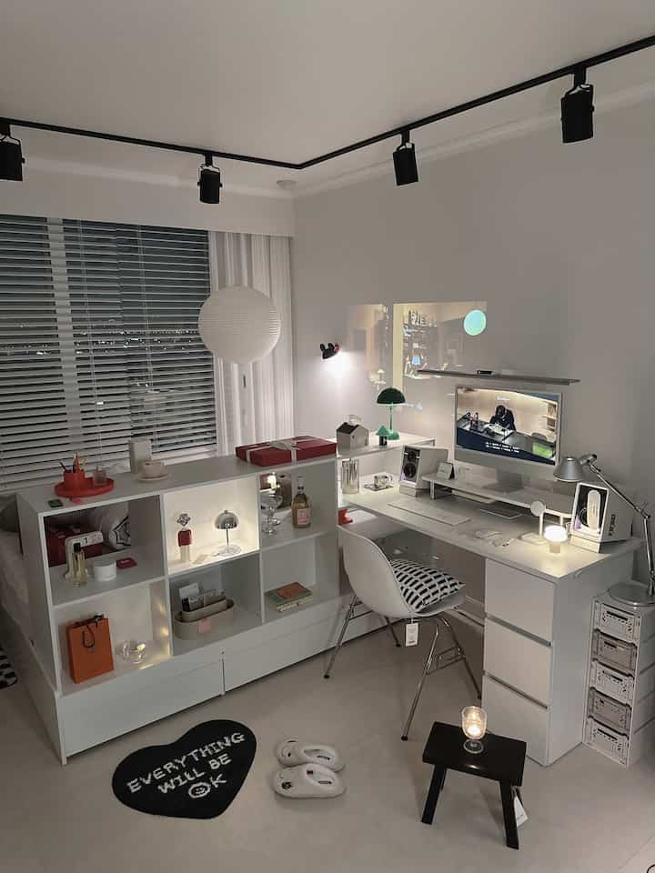 A white-toned studio apartment small room featuring a desk, desk lamps, and computer monitor in a modern home office setup