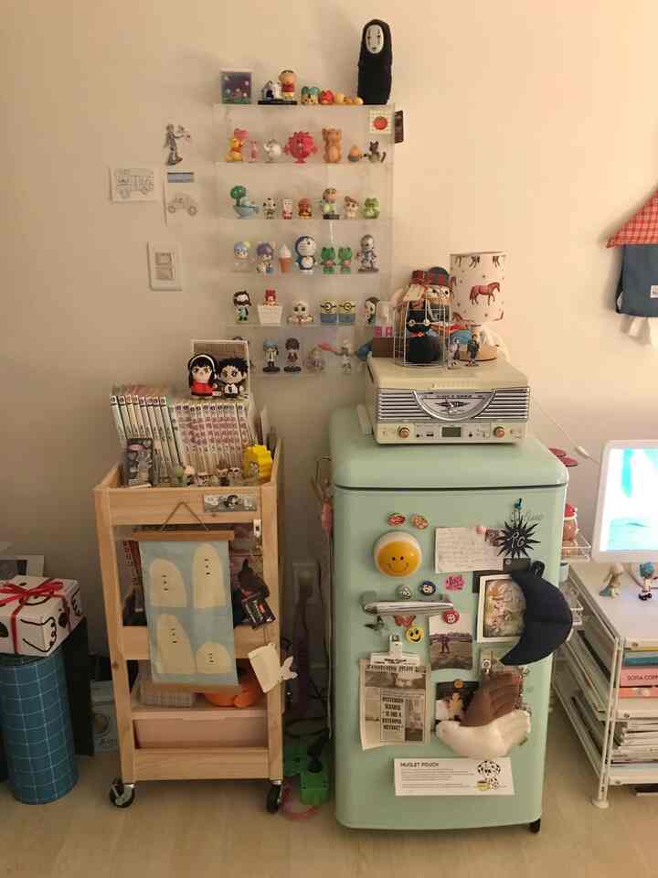 ミント色のレトロなミニ冷蔵庫と多数の玩具収納が配置された一人暮らしの温かみのある小さなキッチンスペース