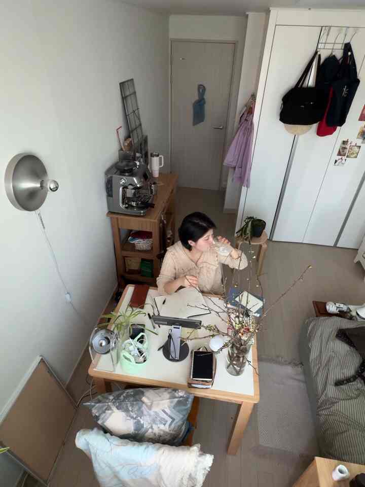 白と木目調が調和する小さな部屋のホームカフェ空間、デスクとコーヒーマシンが配置された落ち着いた雰囲気のあるインテリア