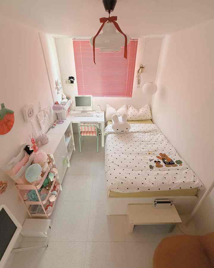 ピンクのブラインドとホワイト家具が調和した狭くて居心地の良い子供部屋のインテリア