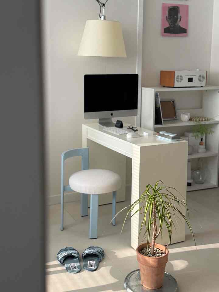 ホワイトとパウダーブルーのトーンのホームオフィス、スツールと植物が配置された清潔でナチュラルな雰囲気のインテリア