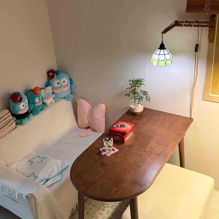 白い壁とソファ、木目調のダイニングテーブルが配された居心地の良い一人暮らしのリビング