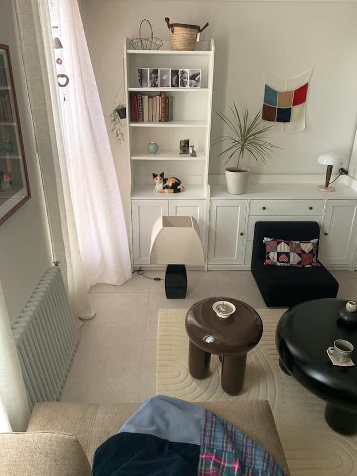 ホワイトとブラウンの色調のリビング、ベージュのソファとブラウンのコーヒーテーブルが配置された、シンプルでナチュラルな雰囲気のある空間