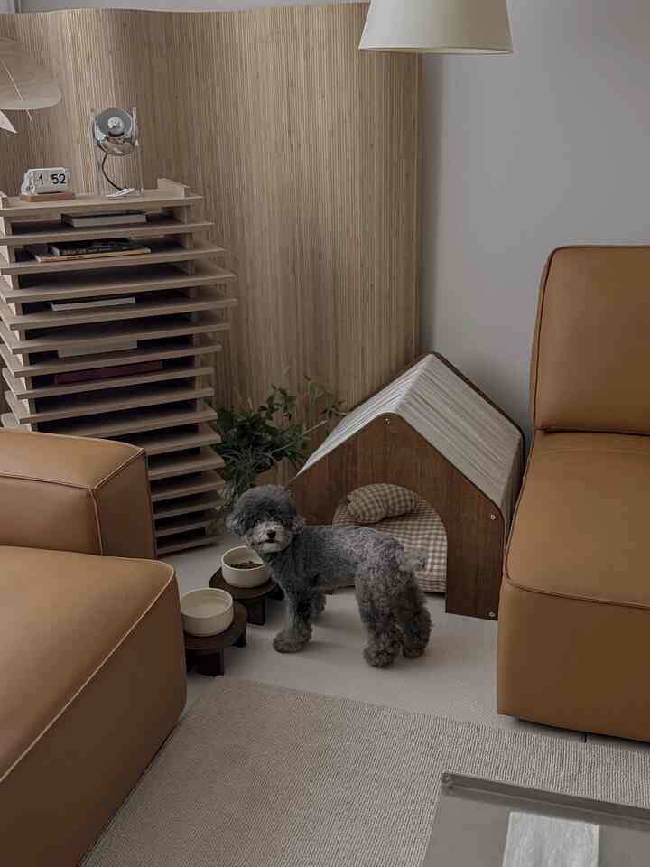 ベージュのカーペットと木目調家具が配置されたリビング、犬用ペットハウスと食器がある落ち着いた雰囲気のインテリア