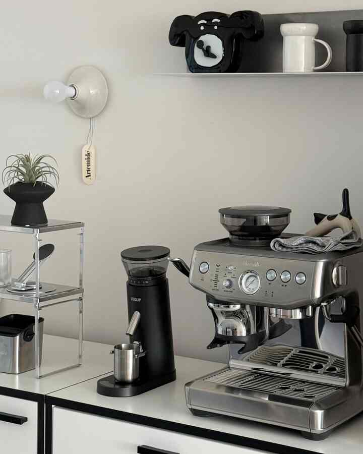 白と黒のトーンでまとめられたキッチン空間、ブレビルのコーヒーマシンとグラインダーが清潔感あるミニマルな雰囲気を演出