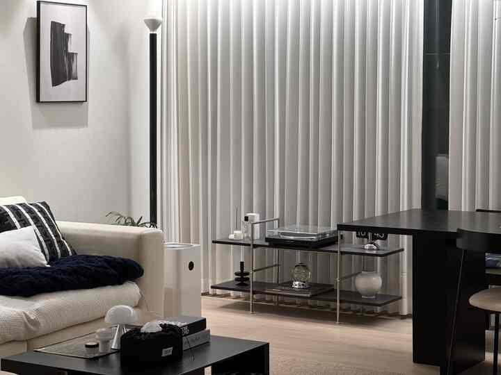 A natural modern living room with harmonious white and black tones, featuring a sofa and coffee table in a clean, minimalist interior