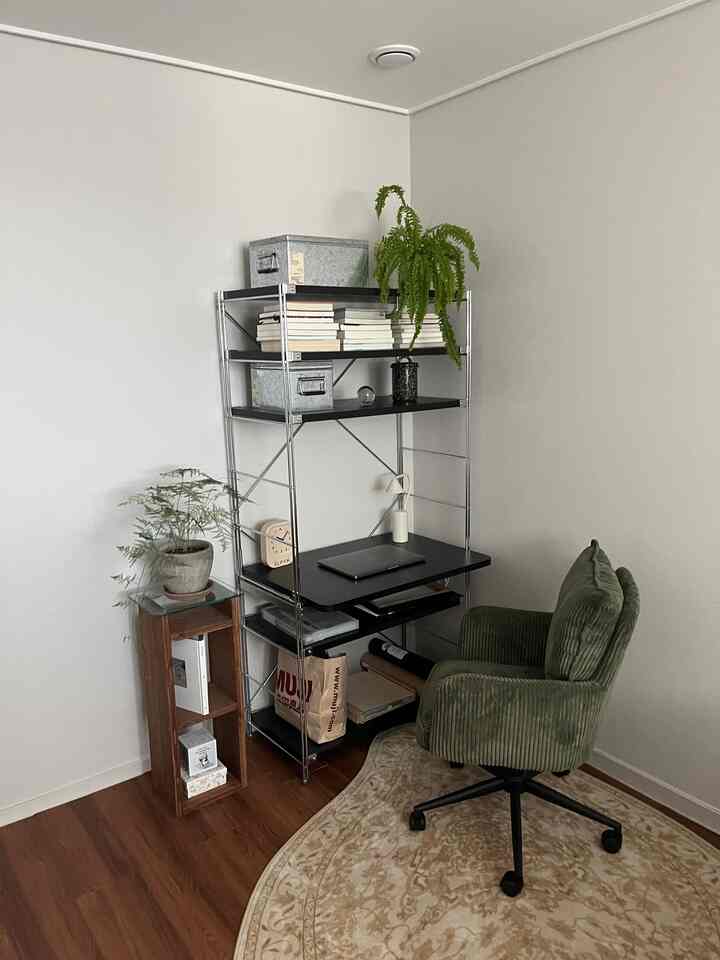 チャコールとブラックのトーンのコンパクトなホームオフィス、デスク、グリーンのオフィスチェアと植物が配置されたシンプルで自然な雰囲気のインテリア