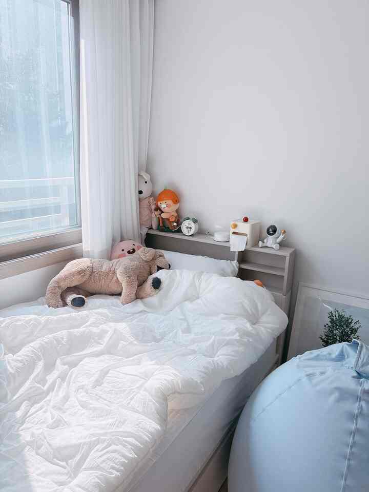ホワイトトーンの子供部屋、収納ベッドとブルーのビーズクッションが配置された清潔で居心地の良いインテリア