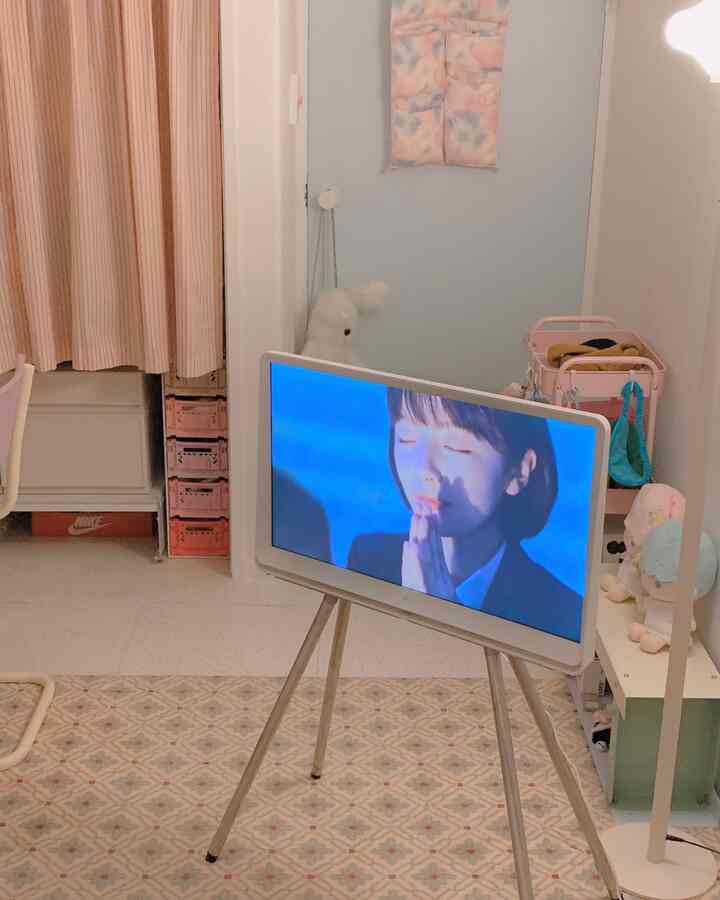 パステルブルーとホワイトの6畳リビング、中央にTVスタンドとシンプルな家具が配置された落ち着いたインテリア