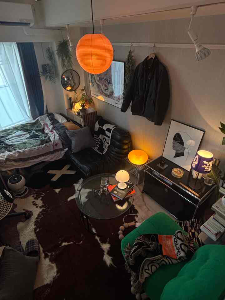 An 8-tatami sized single household studio apartment featuring an orange pendant light and black leather sofa