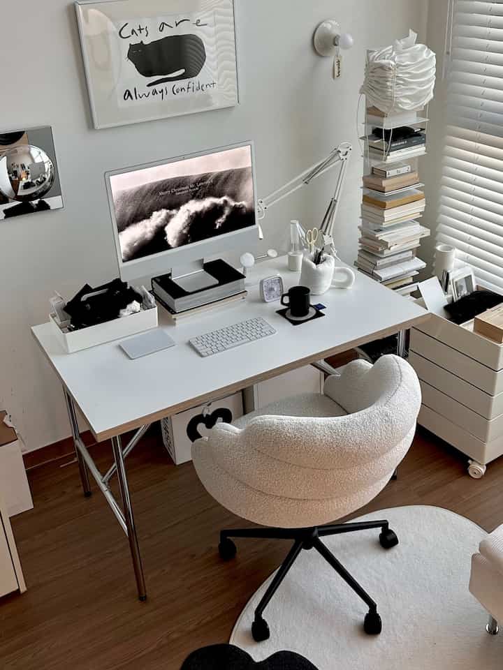White and brown toned home office featuring desk, computer, and a cat poster in a neat workspace