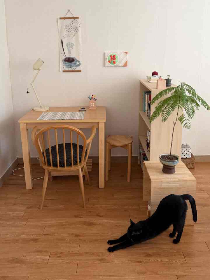 ナチュラルな色調のホームオフィス、木製家具と緑の植物が配置されたシンプルで落ち着いた雰囲気のインテリア