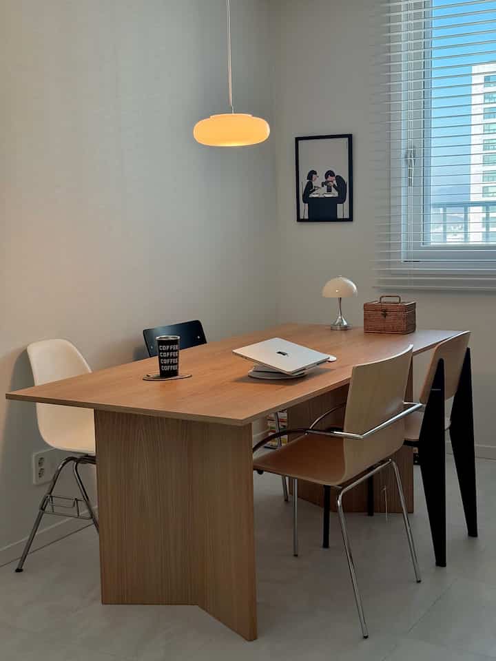 ナチュラルな木目調のテーブルとモダンな椅子が配置された明るく清潔感のあるダイニングルーム