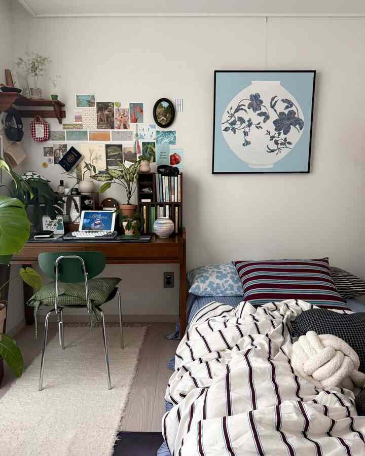 明るく自然な色調の寝室兼ホームオフィス、木製のデスクと植物が配置された温かな空間