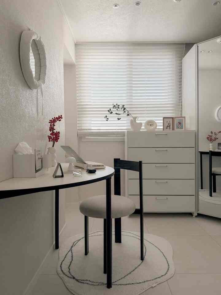 White and black toned walk-in closet featuring a compact home office desk zone with a simple modern atmosphere