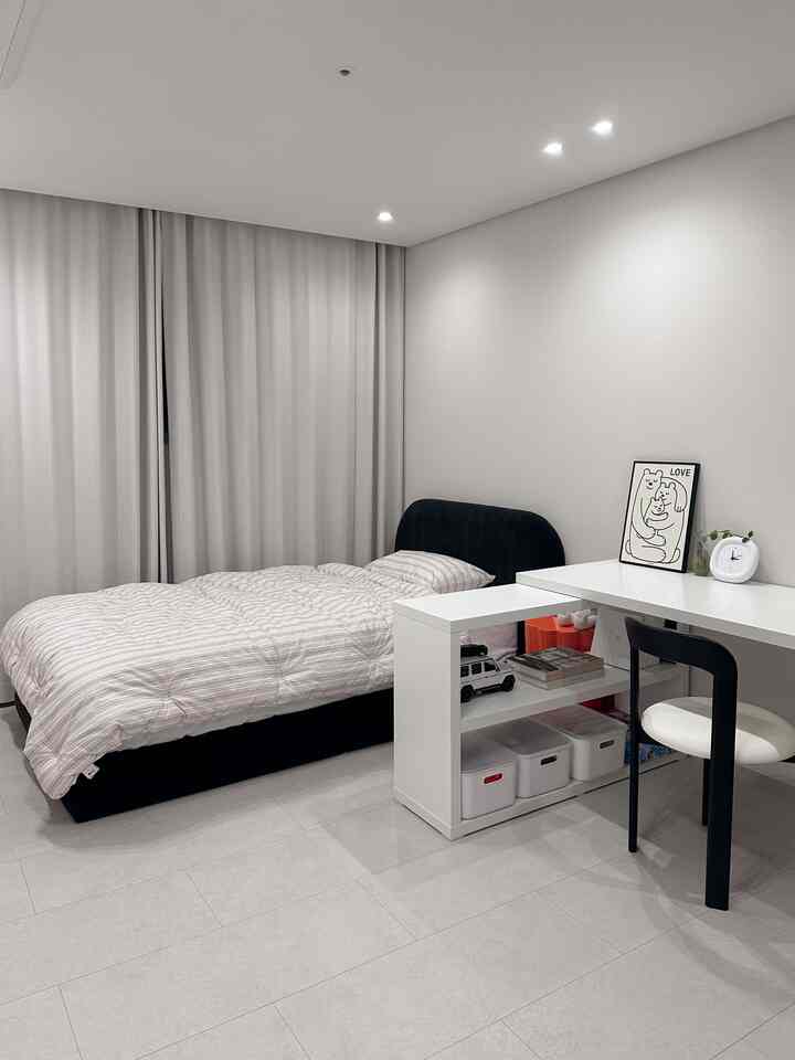 ベージュと白の色調の子供部屋、シンプルなデザインのベッドとデスクが配置された雰囲気のあるインテリア