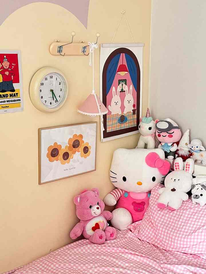 ピンクのチェック柄寝具とかわいいぬいぐるみが配置されたベージュ色の子供部屋の温かみのあるインテリア