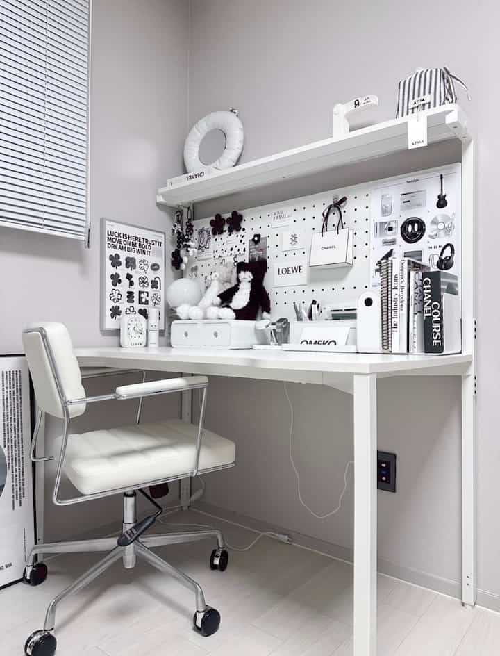 Monotone white desk and chair arranged in a clean and organized home office space