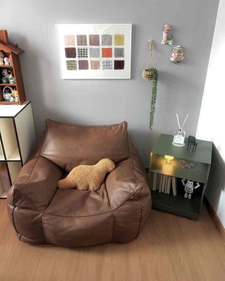 落ち着いたブラウンのビーンバッグソファとグリーンのトロリーがあるコンパクトな書斎スペース