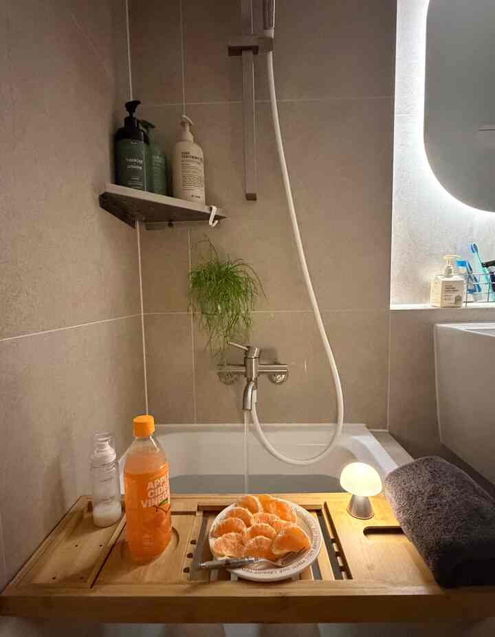 ナチュラルトーンのバスルーム、竹製のハーフバストレイと浴槽が配置された落ち着いた雰囲気のあるインテリア