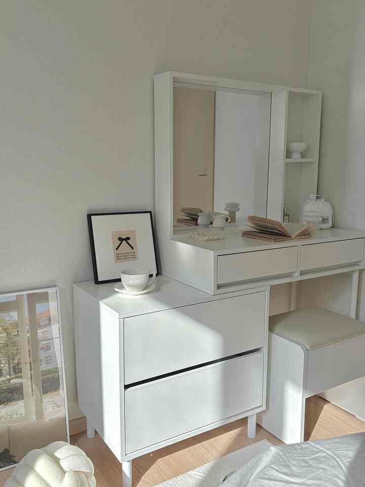 Bright white and natural wood-tone bedroom vanity with stool arranged in a minimalistic space