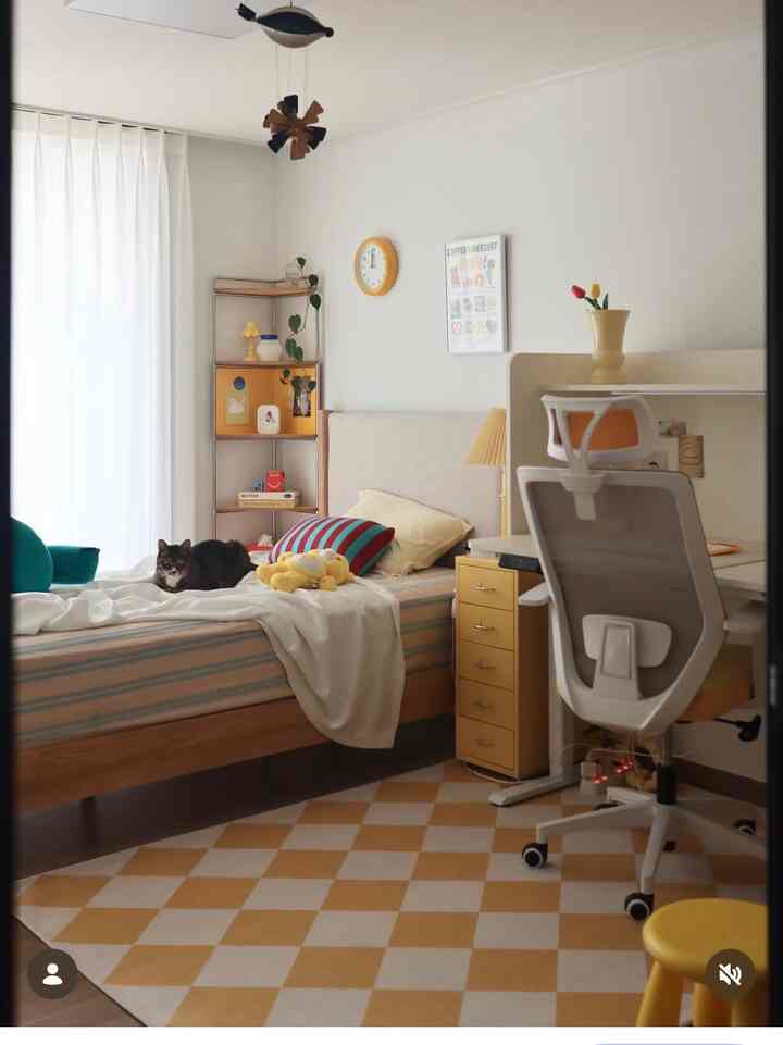 黄色とベージュの色調の寝室、ベッドの上に猫がいて、机とナイトテーブルが配置された雰囲気のあるインテリア