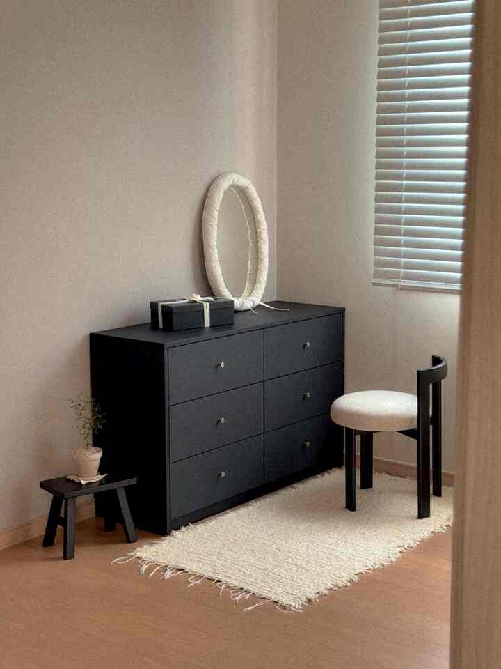 I had a vague idea that black furniture would be too complicated.
I never imagined how organized the space would be once I brought it in.

A single matte black six-drawer dresser really brought out the right atmosphere. Placing it next to a window with a white wall and an ivory rug, it didn't feel cold at all. Instead, it created a calm and luxurious atmosphere.

With six drawers, it holds more than I expected, and the neat organization of small items makes the space feel much larger.

A fabric mirror and a small plant on the countertop gently neutralized the inherent heaviness of black.

I had a preconceived notion that black furniture was too overwhelming, but matte black furniture is completely different.
These days, I find myself looking at this space a second time whenever the sunlight streams in.

And a photo of my space was used as the thumbnail. This chest of drawers is so special  #소품 #러그인테리어 #집스타그램 #의자인테리어 #식집사 #식물일기 #식물 #블랙앤화이트인테리어 #블랙인테리어 #블랙 #좋아요