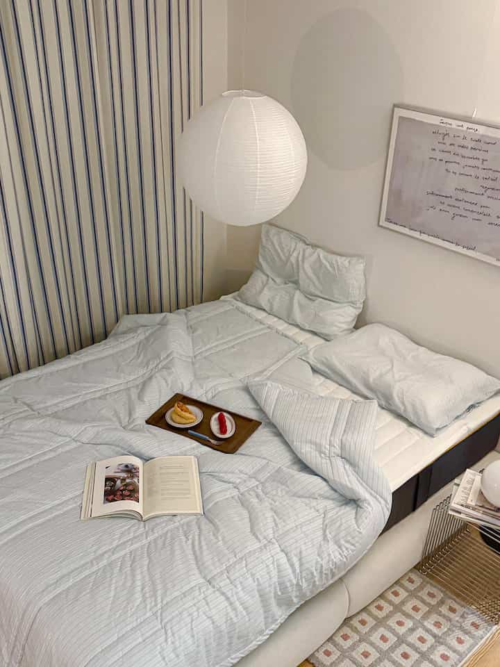 Cozy bedroom in white and beige tones featuring comfortable bedding and soft lighting