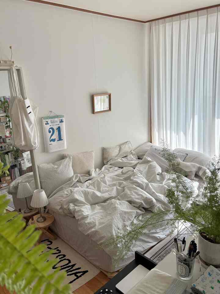 White and beige toned bedroom featuring bed and curtains with a natural and simple atmosphere