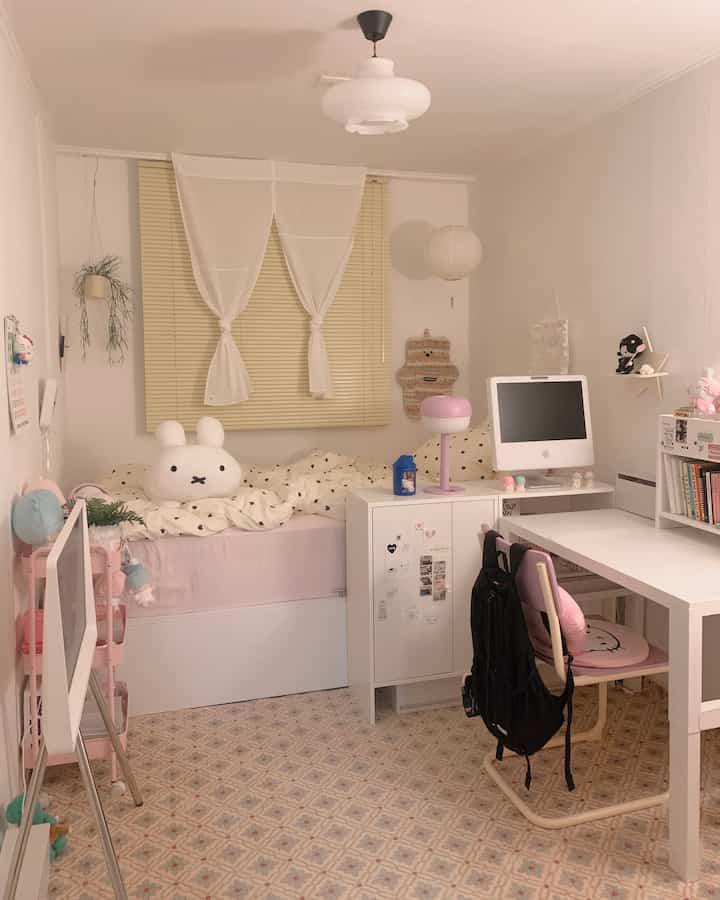 白を基調とした子供部屋、収納付きベッドとデスク、ブラインドが配置された落ち着いた小さな空間