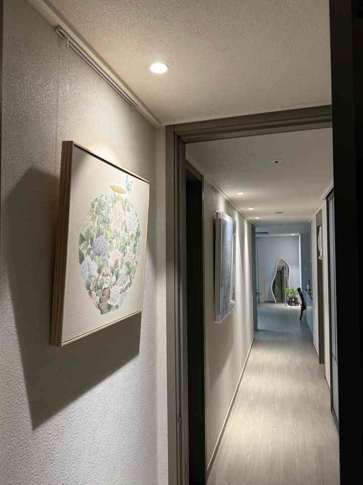 家の第一印象である廊下をギャラリーのように作りたかったので、2インチの照明を壁側に施工しました。 ✨
お部屋は最近ホットなワビサビムードを盛り込んでディアマンサンドアイボリーに仕上げます！
お茶の入り口には福を呼ぶという月壺の絵を歩いておくと心まで心強いですね。 
私の家に福がたっぷり入ってくる！ 🌕🤍

＃オンラインハウス＃廊下のインテリア＃ワビサビ＃ディアマンサンドアイボリー＃月の壺の絵