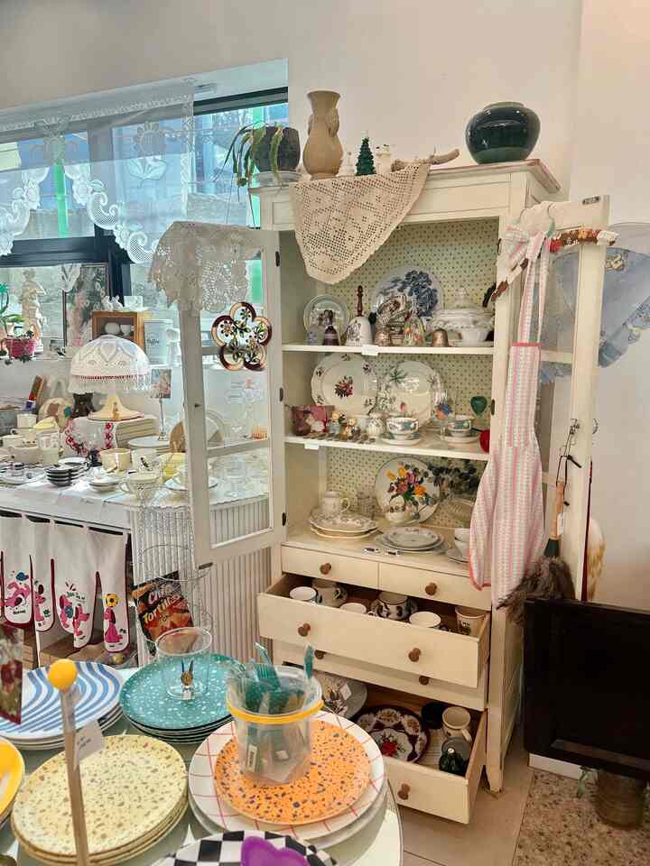 ベージュと白を基調としたキッチンスペース、ヴィンテージ風の食器棚がダイニングテーブル横に置かれた雰囲気のある空間