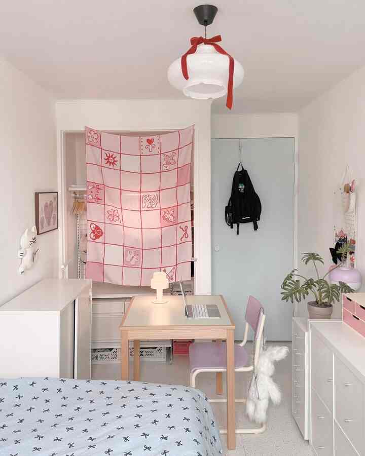 White and pink toned bedroom featuring desk and bed with a simple and cozy interior design